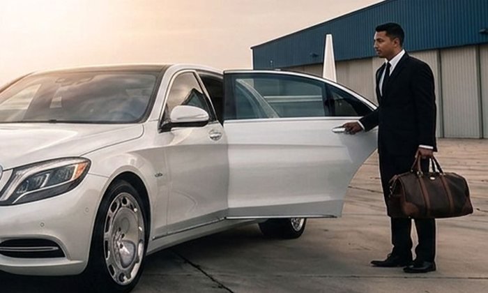 A BTT Travels chauffeur holding the door of an executive sedan
